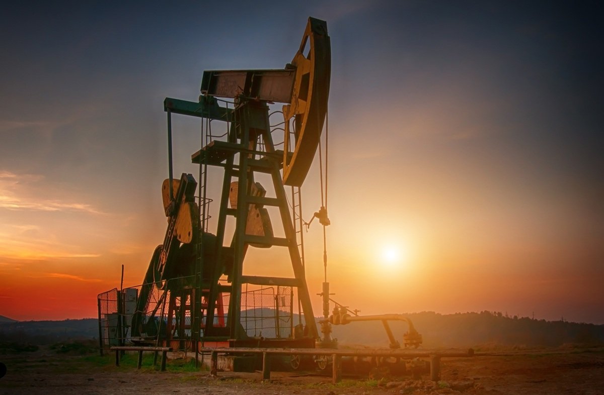 Oil pump jack working at golden-hour sunset, illustrating depleting oil and gas reserves