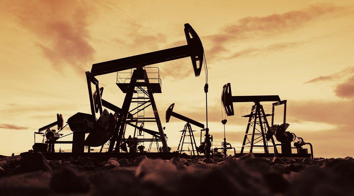 Row of oil pump jacks operating at golden sunset across a U.S. oil and gas basin